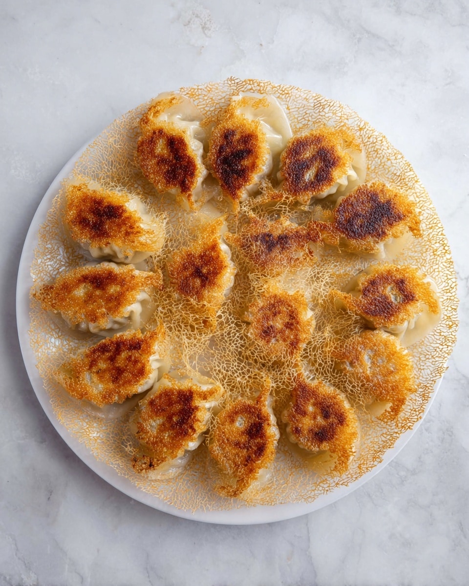 A white plate holds a round layer of golden brown crispy mesh with many small holes, connecting 12 pan-fried dumplings arranged in a circle. Each dumpling has a browned, slightly shiny bottom, and pale tops with soft folds. The lacy crispy layer spreads evenly out from under the dumplings, creating a delicate, thin texture that looks crunchy. The plate sits on a white marbled texture surface. Photo taken with an iphone --ar 4:5 --v 7