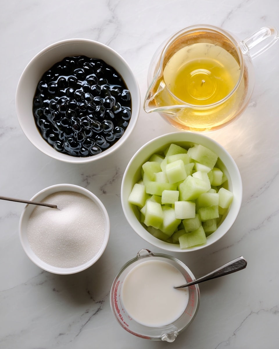 The image shows a top view of several ingredients arranged on a white marbled surface: a white bowl filled with shiny black boba pearls on the left, a white bowl with small cubes of light green honeydew melon in the center, a small white bowl of white granulated sugar at the bottom left with a spoon inside, a clear measuring cup filled with white milk below the honeydew bowl, and a glass teapot with light golden green tea on the right. The setup is clean and simple with soft natural light. Photo taken with an iphone --ar 4:5 --v 7