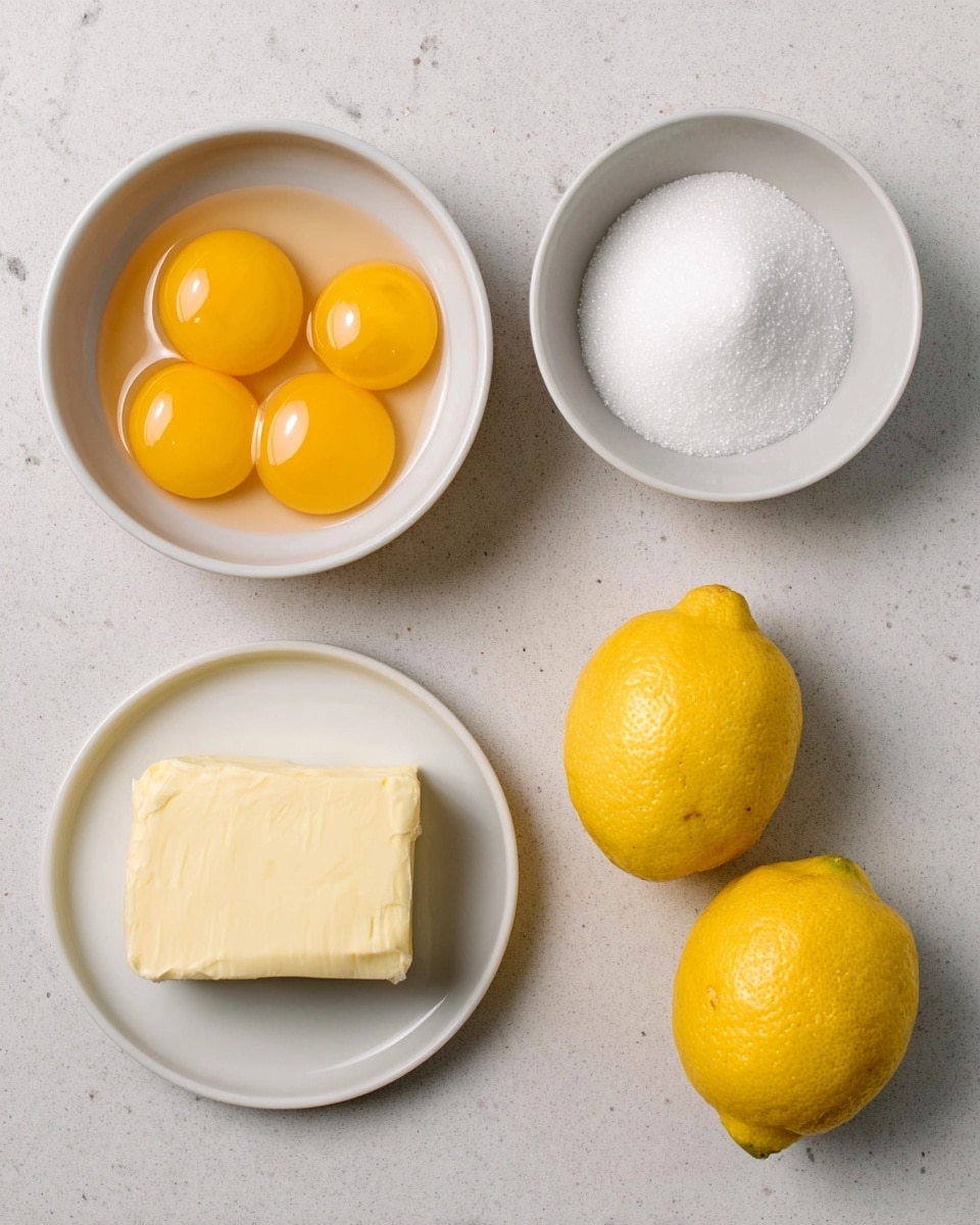 The image shows four white bowls and two whole lemons on a white marbled surface. The top left bowl contains seven bright yellow egg yolks, shiny and smooth. To its right, there is a bowl filled with white granulated sugar, looking soft and fine. Below the sugar, a small white plate holds a solid block of pale yellow butter with a textured surface. Between the bowls, two whole fresh lemons with bright yellow, slightly bumpy skin sit side by side. The scene is simple and clean, with all items evenly spaced. Photo taken with an iphone --ar 4:5 --v 7