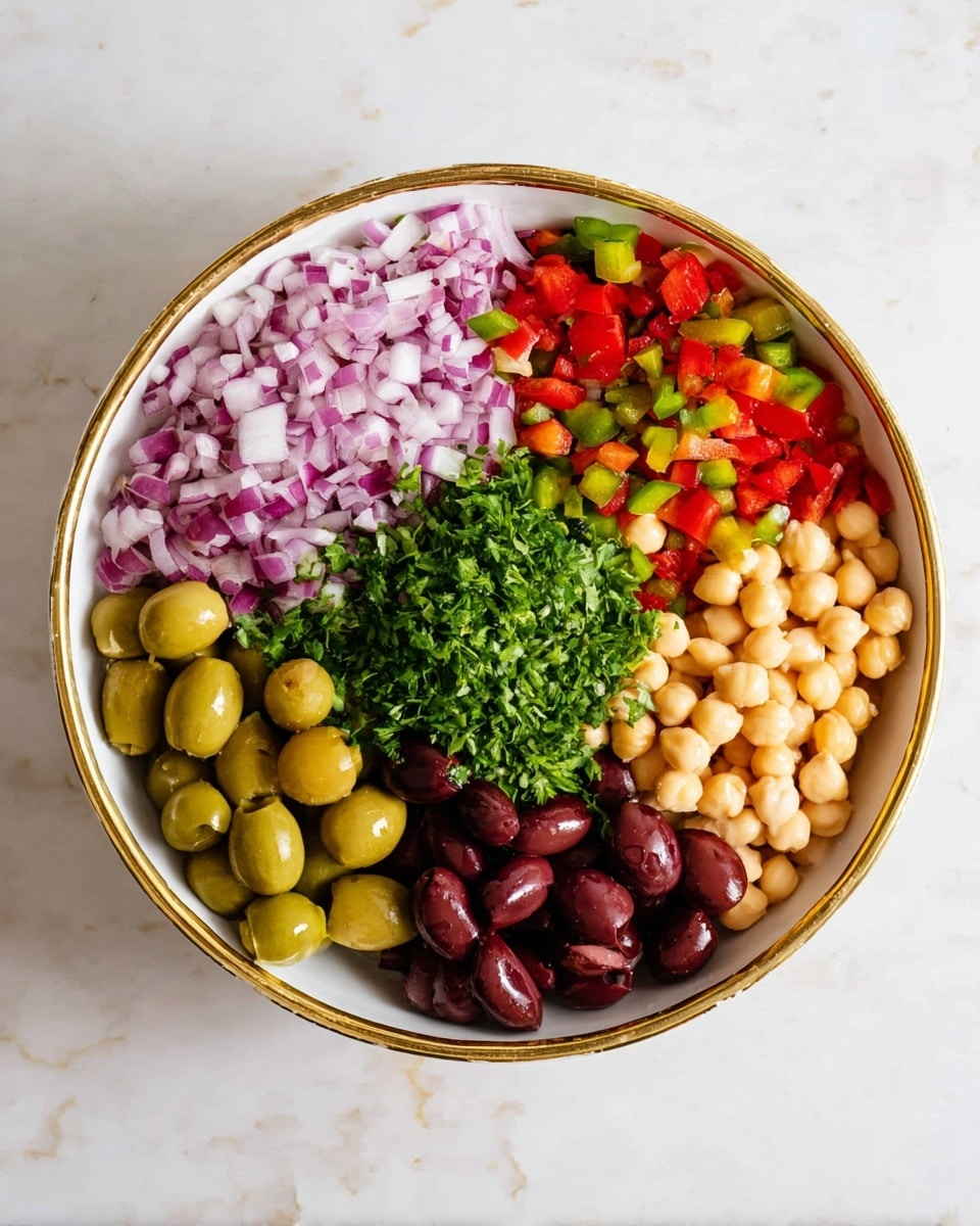 A white bowl with a gold rim filled with six distinct layers of salad ingredients arranged side by side: finely chopped purple and white onion at the top center, bright red and green chopped bell peppers to the right, light beige chickpeas at the far right, dark purple Kalamata olives at the bottom left, green whole olives just above the Kalamata olives, and fresh green chopped parsley placed between the green olives and onions. The bowl is on a white marbled surface. photo taken with an iphone --ar 4:5 --v 7