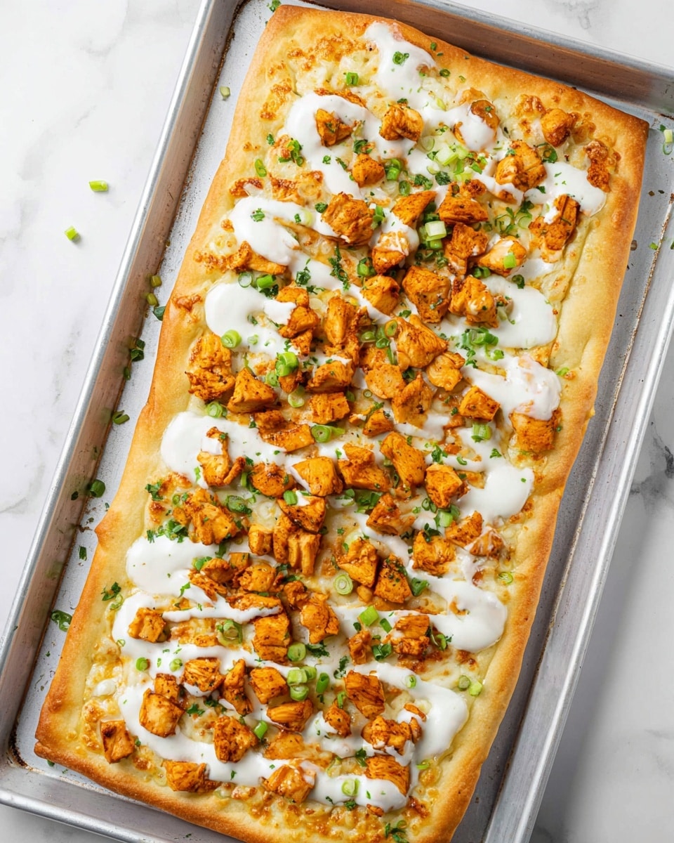A rectangular pizza with a golden brown crust that looks crispy on the edges sits on a white baking tray with some green onion pieces scattered around. The first layer is melted white cheese spread evenly on the dough. On top of that, there are many small chunks of seasoned cooked chicken in a bright orange color, spread evenly but leaving some cheese visible. White creamy sauce is drizzled over the chicken pieces in a loose spiral pattern. The final layer is chopped green onions sprinkled across the pizza, adding small pops of green color. The scene is set against a white marbled surface. Photo taken with an iphone --ar 4:5 --v 7