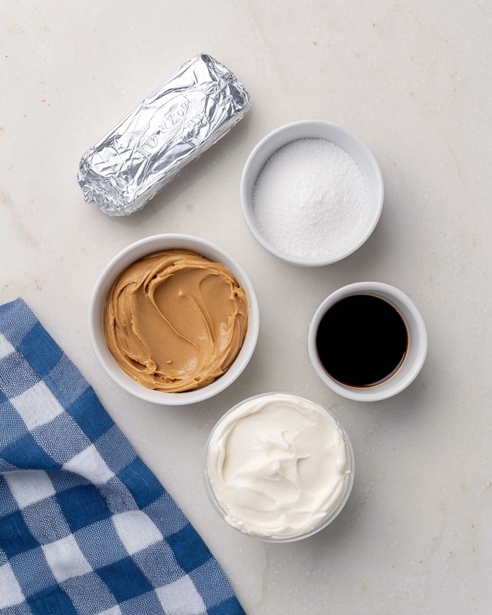 The image shows five ingredients arranged on a white marbled surface: a silver wrapped butter stick at the top left, a small white round bowl of smooth peanut butter in light brown color to the right, a small black cup of dark liquid below the butter, a white bowl filled with white powdered sugar below the dark liquid, and a round container of white creamy substance at the bottom, with the lid beside it. A blue and white checkered cloth is seen at the bottom left corner. Photo taken with an iphone --ar 4:5 --v 7