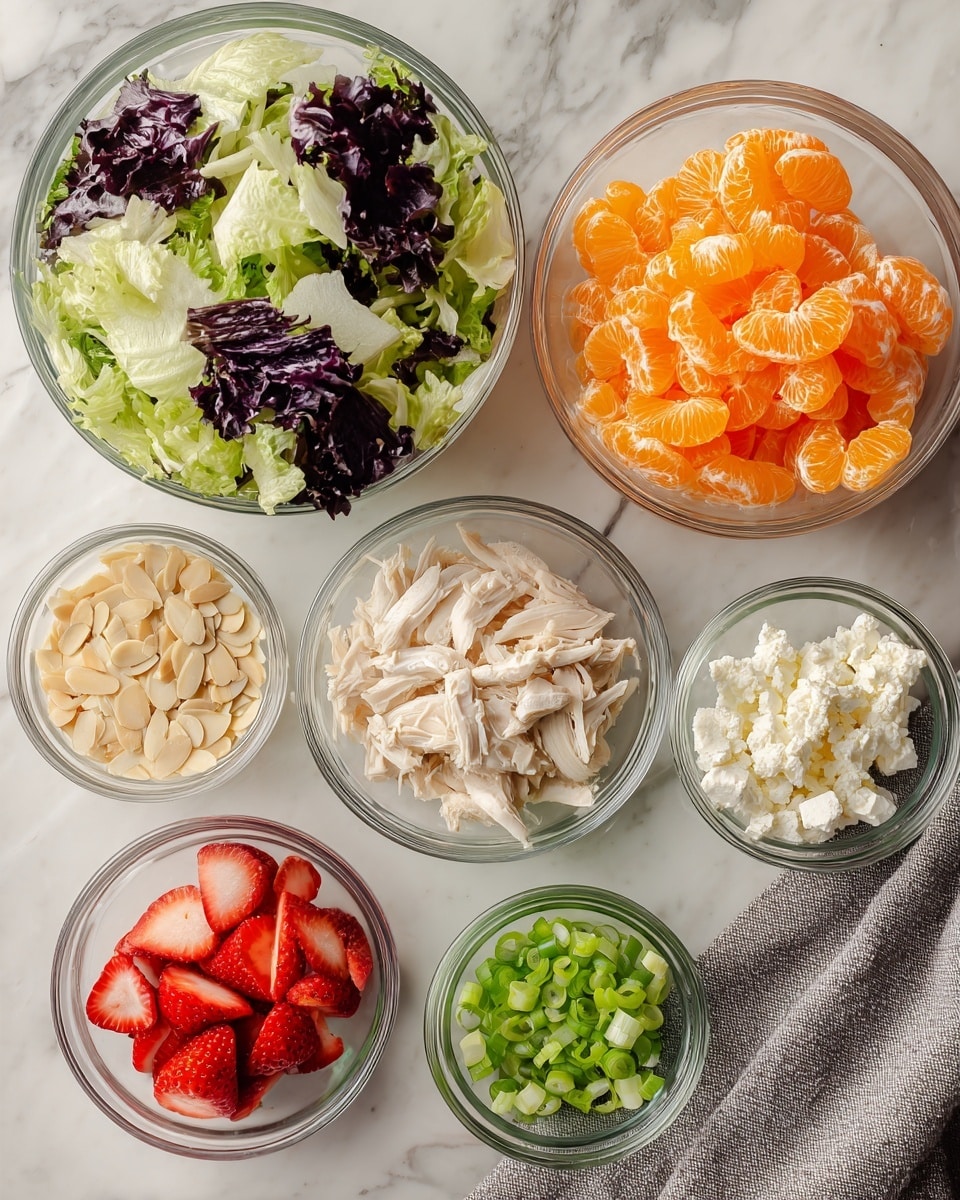 The image shows seven clear glass bowls arranged on a white marbled surface. The largest bowl on the left contains chopped lettuce with a mix of dark purple and green leaves. To the right, one medium bowl holds bright orange mandarin orange segments with a shiny and juicy texture. Another medium bowl next to it contains shredded white chicken pieces. Below these, a small bowl is filled with thin, light tan sliced almonds. Near it, another small bowl shows fresh, sliced red strawberries with white centers. Below these, one small bowl has white crumbly feta cheese. Finally, a tiny bowl with bright green sliced green onions rounds out the ingredients. A grey cloth is partially visible under the lettuce bowl. photo taken with an iphone --ar 4:5 --v 7