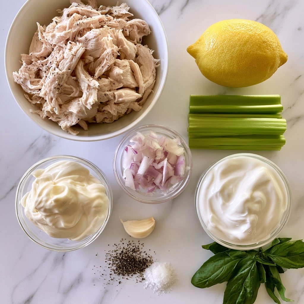 The image shows ingredients arranged neatly on a white marbled surface. At the top left, there is one large white bowl filled with shredded chicken, light beige with some black pepper specks visible. To the right of this bowl, there is a whole bright yellow lemon. Below the lemon, three green celery sticks are placed side by side. Toward the center, a small clear bowl holds finely chopped red onion in light purple and white hues. Next to it, on the left, another clear bowl contains thick, creamy white mayonnaise, and to the right, a similar bowl holds smooth plain Greek yogurt, also white. Below these bowls, a single peeled garlic clove sits on the surface alongside small piles of coarse black pepper and white salt. At the bottom right corner, there is a cluster of fresh dark green basil leaves. Everything is spaced evenly on the white marbled background. Photo taken with an iphone --ar 4:5 --v 7