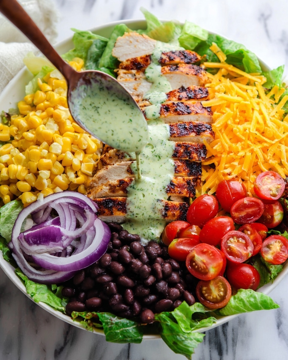 A white bowl holds a colorful salad with five main layers: at the base is a bed of fresh green lettuce leaves, topped with sliced grilled chicken breast arranged in the center. To the left, thinly sliced purple-red onions lie next to bright yellow corn kernels mixed with a light green herb sauce. Below the corn, black beans form a dark, smooth layer. On the right, halved red cherry tomatoes sit next to shredded orange-yellow cheddar cheese. A spoon with thick green herb dressing is held above the grilled chicken, with some dressing drizzled on the chicken and vegetables. The background is a white marbled surface. Photo taken with an iphone --ar 4:5 --v 7